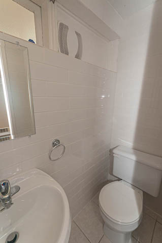 Bathroom with white tiles, sink, toilet, and mirror. - 669 Eyremount Drive, West Vancouver
