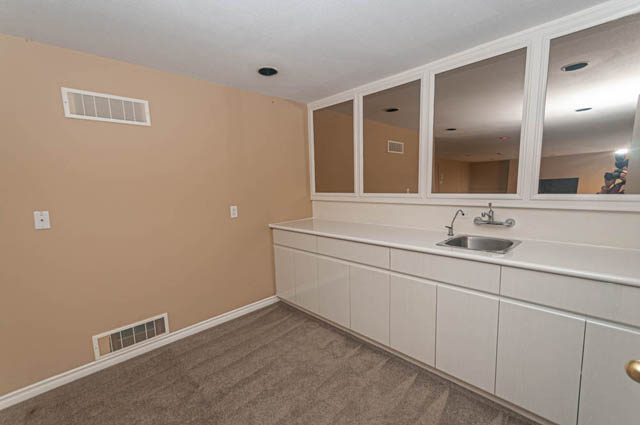 Bright kitchen with white cabinets, granite countertops, and a large window offering a city view. - 669 Eyremount Drive, West Vancouver