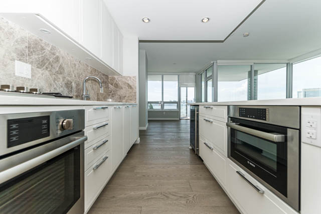 Bright kitchen with marble countertops, hardwood floors, and a city view. - 802 - 118 Carrie Cates Court, North Vancouver