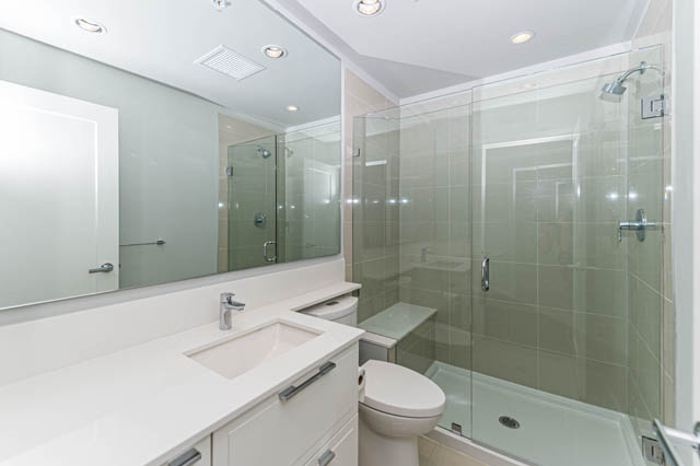 Bright bathroom with white countertops and glass shower enclosure. - 802 - 118 Carrie Cates Court, North Vancouver