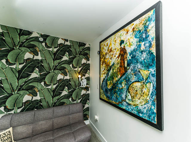 Furnished living room with tropical banana leaf wallpaper and abstract art. - 501 - 231 E Pender Street, Vancouver Downtown