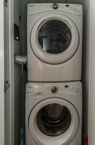 Bright laundry room with stacked white Whirlpool washer and dryer, clean and organized. - 501 - 231 E Pender Street, Vancouver Downtown