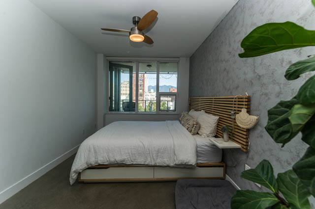 Bright bedroom with city view, modern ceiling fan, and plush bedding. - 501 - 231 E Pender Street, Vancouver Downtown