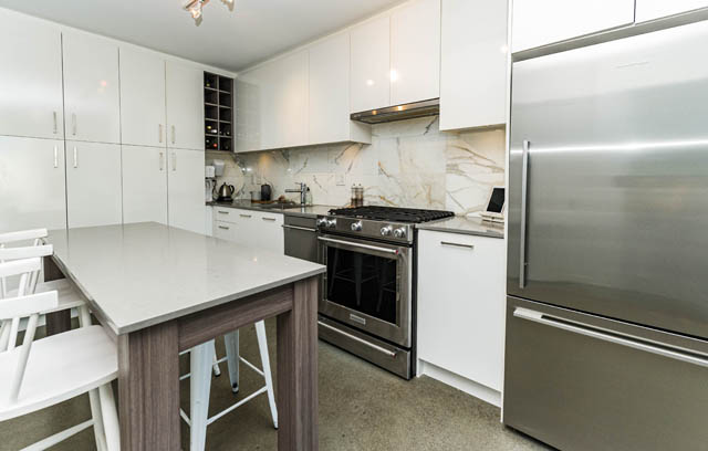 Bright kitchen with white cabinets, marble backsplash, and stainless steel appliances. - 501 - 231 E Pender Street, Vancouver Downtown