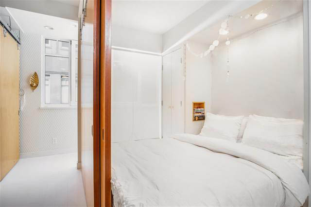 Bright, modern bedroom with white walls and a cozy bed setup. - 410 - 1072 Hamilton St, Vancouver Downtown