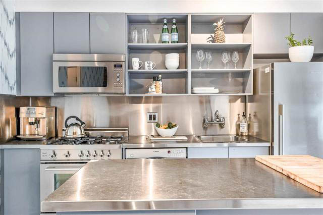 Bright kitchen with modern stainless steel appliances, marble countertops, and open shelving. - 410 - 1072 Hamilton St, Vancouver Downtown