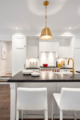 Bright kitchen with white cabinetry, black countertops, and a brass pendant light. - 201 - 1785 W 16th Avenue, Vancouver West Side