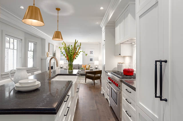 Bright kitchen with modern white cabinetry, granite countertops, and gold pendant lights. - 201 - 1785 W 16th Avenue, Vancouver West Side