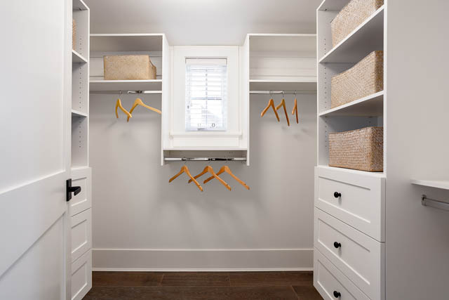 Spacious walk-in closet with white cabinetry, wooden hangers, and woven baskets. - 201 - 1785 W 16th Avenue, Vancouver West Side