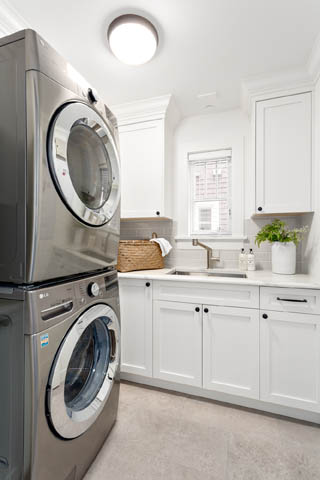 Bright laundry room with white cabinets, stainless steel appliances, and a window above the sink. - 201 - 1785 W 16th Avenue, Vancouver West Side