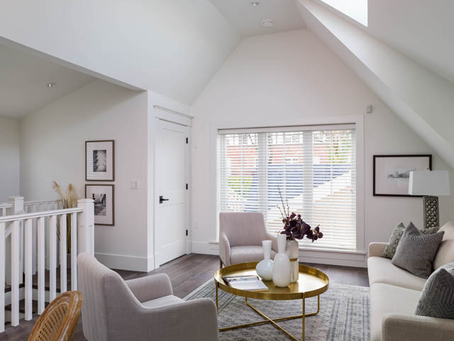 Spacious living room with vaulted ceilings, white walls, and a gold coffee table. - 3170 Burrard St, Vancouver West Side