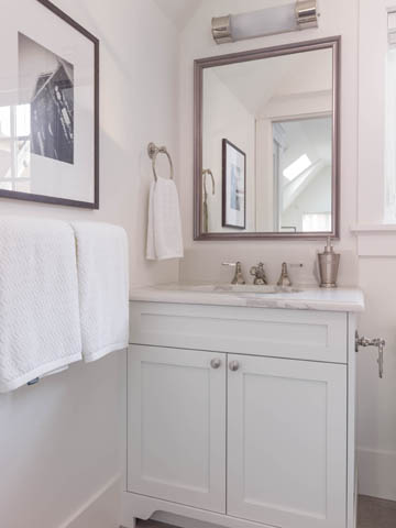 Bright bathroom with white cabinetry, marble countertops, and a large mirror. - 3170 Burrard St, Vancouver West Side