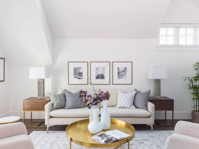Bright living room with gold coffee table, white couch, and gallery wall art. - 3170 Burrard St, Vancouver West Side