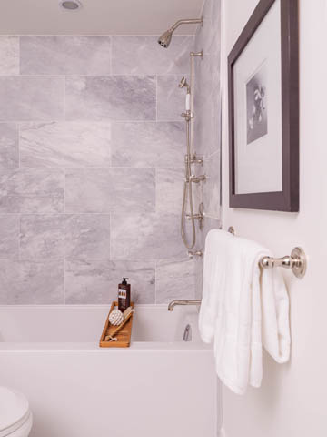 Furnished bathroom with marble tiles and a modern shower setup. - 3170 Burrard St, Vancouver West Side