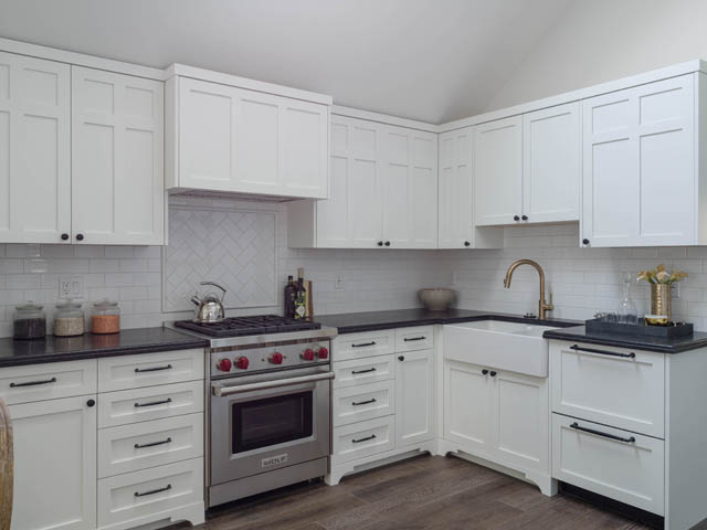 Bright kitchen with white cabinets, black countertops, and stainless steel appliances. - 3170 Burrard St, Vancouver West Side