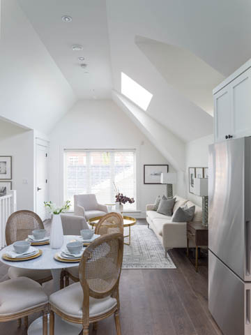 Bright dining area with hardwood floors and a skylight, featuring a round table and wicker chairs. - 3170 Burrard St, Vancouver West Side