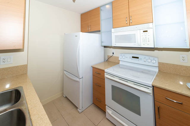 Bright kitchen with light countertops and wooden cabinets, modern appliances. - 1602 - 977 Mainland Street, Vancouver Downtown
