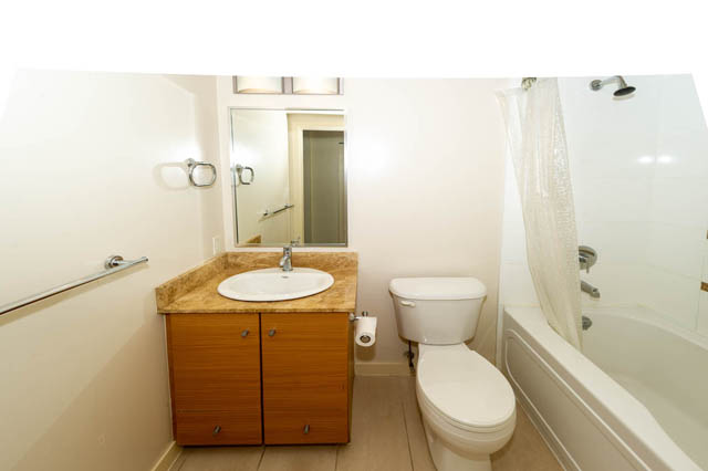 Furnished 1-bedroom bathroom with granite countertops and wooden cabinets. - 1602 - 977 Mainland Street, Vancouver Downtown
