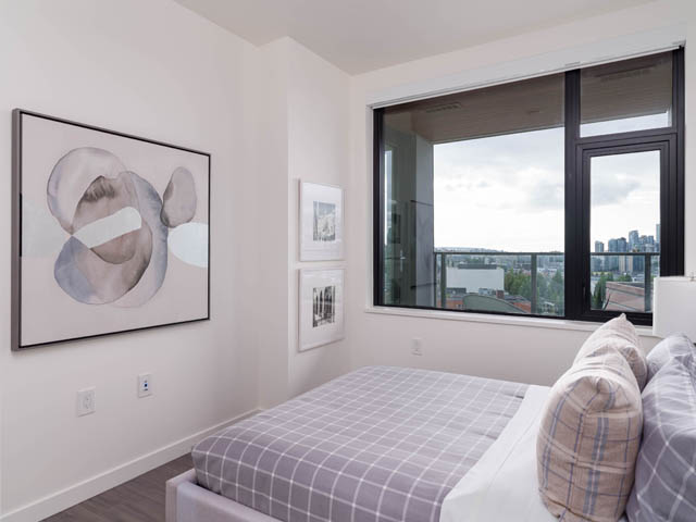 Bright bedroom with large windows offering a city view and modern artwork on the walls. - 805 -  210 E 5th Avenue, Vancouver East Side