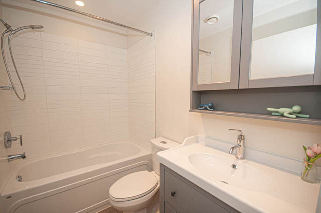 Bathroom with white tile, modern fixtures, and a bathtub. - 117 - 3478 Westbrook Mall, Vancouver West Side