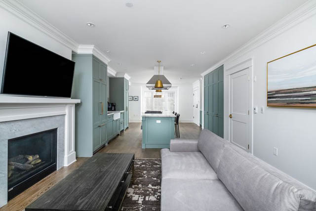 Furnished living room with teal cabinets, hardwood floors, and a fireplace. - 200 - 1775 W 16th Avenue, Vancouver West Side