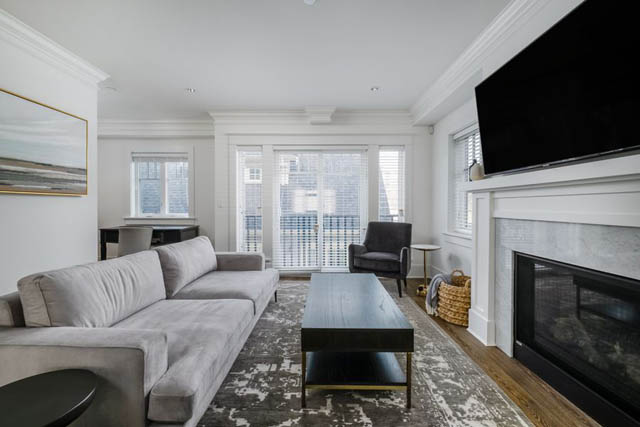 Spacious living room with large windows, modern furniture, and a fireplace. - 200 - 1775 W 16th Avenue, Vancouver West Side
