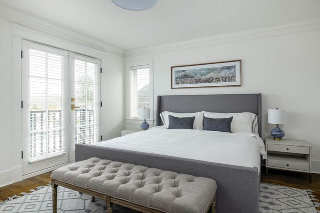 Bright bedroom with white walls, large windows, and a gray tufted ottoman. - 200 - 1775 W 16th Avenue, Vancouver West Side