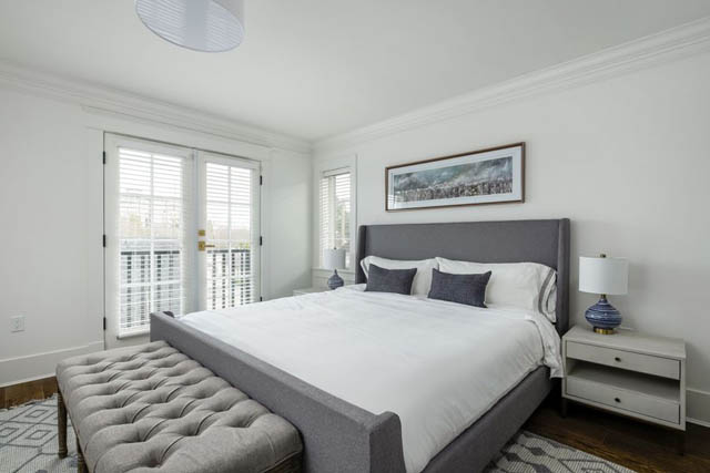 Spacious bedroom with large windows, tufted bench, and modern decor. - 200 - 1775 W 16th Avenue, Vancouver West Side