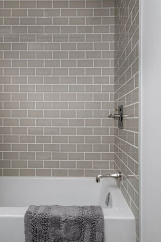 Bathroom with subway tile walls, modern faucet, and white bathtub. - 200 - 1775 W 16th Avenue, Vancouver West Side