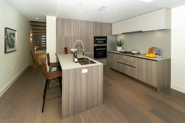 Modern kitchen with light wood cabinets, granite countertops, and hardwood floors. - 146 W Woodstock Ave, Vancouver West Side