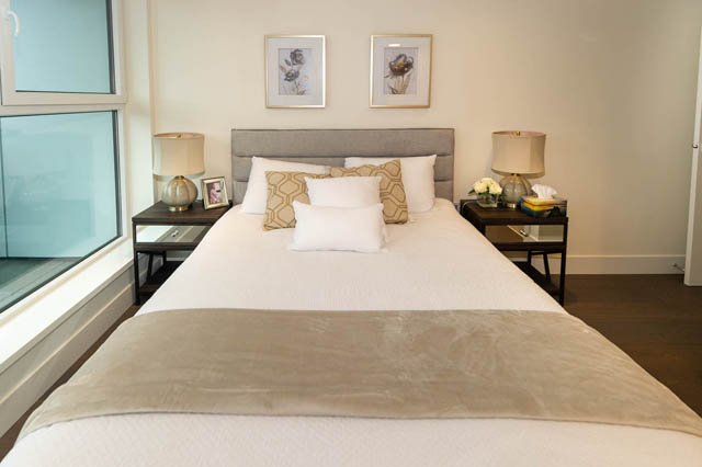 Spacious bedroom with a large bed, neutral tones, and two nightstands with lamps. - 146 W Woodstock Ave, Vancouver West Side