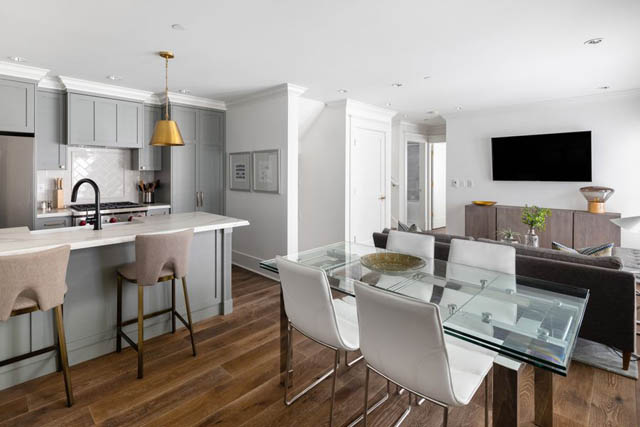 Bright kitchen with gray cabinets, hardwood floors, and a modern dining area with a glass table. - 	1783 W 16th Ave, Vancouver West Side