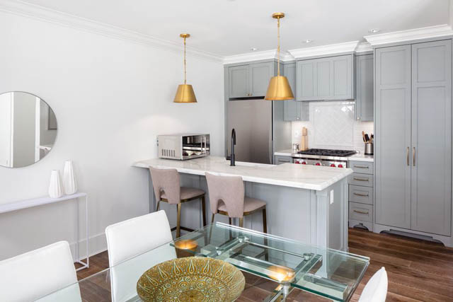 Bright kitchen with white cabinets, glass countertops, and hardwood floors. - 	1783 W 16th Ave, Vancouver West Side