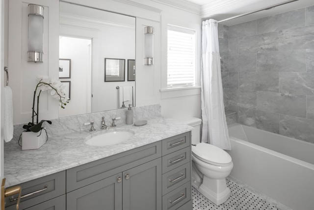 Spacious bathroom with marble countertops and gray cabinets. - 	1783 W 16th Ave, Vancouver West Side
