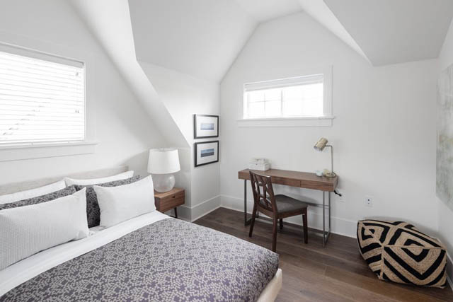 Bright bedroom with slanted ceiling, wooden floors, and patterned bedding. - 	1783 W 16th Ave, Vancouver West Side