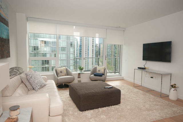 Spacious living room with city view, modern furnishings, and hardwood floors. - 1803 - 620 Cardero Street, Vancouver Downtown