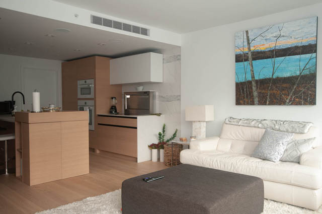 Bright living room with modern furniture, hardwood floors, and a large abstract painting. - 1803 - 620 Cardero Street, Vancouver Downtown