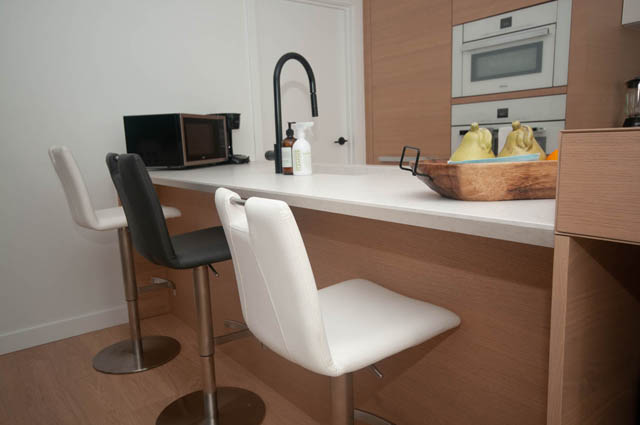 Bright kitchen with white countertops and modern bar stools, hardwood floors. - 1803 - 620 Cardero Street, Vancouver Downtown