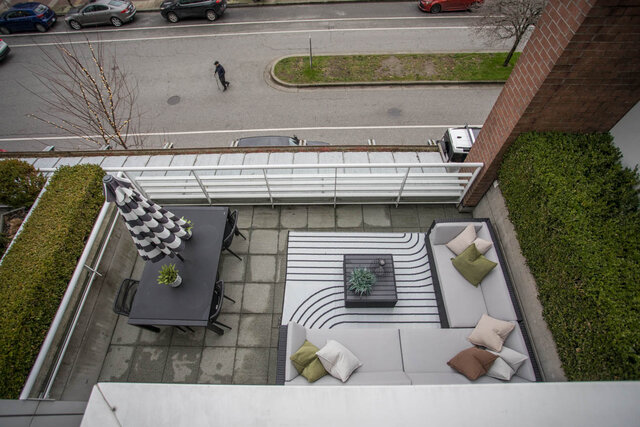 Furnished rooftop patio with modern furniture, greenery, and a view of the street below. - THA - 1199 Marinaside Cres, Vancouver Downtown