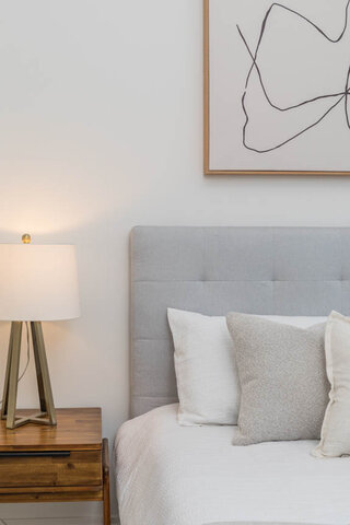 Spacious bedroom with a modern headboard, soft pillows, and a stylish bedside lamp. - THA - 1199 Marinaside Cres, Vancouver Downtown