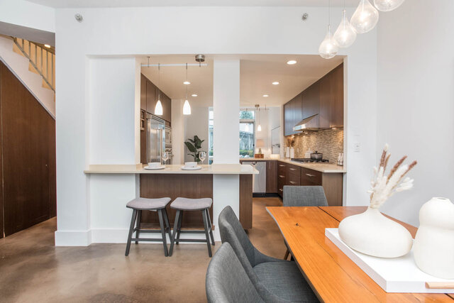 Open-concept kitchen with modern island, hardwood floors, and a city view. - THA - 1199 Marinaside Cres, Vancouver Downtown