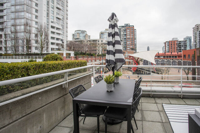 Furnished patio with black and white striped umbrella and cityscape view. - THA - 1199 Marinaside Cres, Vancouver Downtown