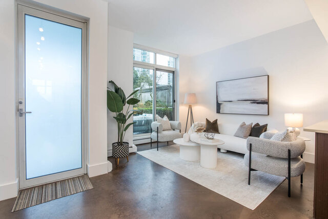 Spacious living room with modern furniture, large windows, and a cozy corner setup. - THA - 1199 Marinaside Cres, Vancouver Downtown