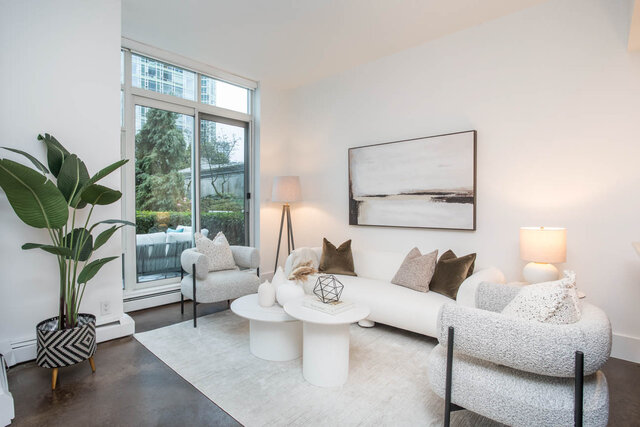 Spacious living room with modern furniture, large windows, and abstract art. - THA - 1199 Marinaside Cres, Vancouver Downtown