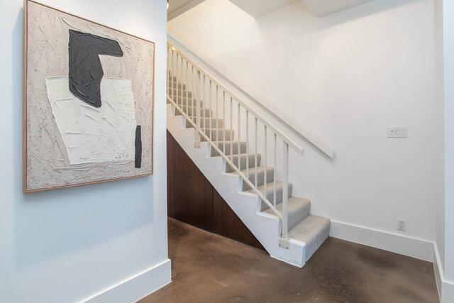 Modern entryway with abstract art and sleek white railings leading to the upper level. - THA - 1199 Marinaside Cres, Vancouver Downtown
