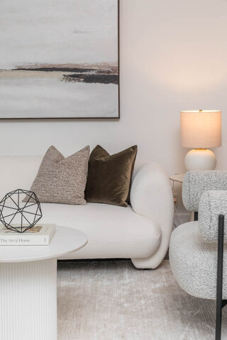 Spacious living room with modern white sofa, abstract art, and cozy throw pillows. - THA - 1199 Marinaside Cres, Vancouver Downtown