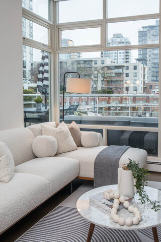 Spacious living room with a large sectional sofa, city view, and modern decor. - THA - 1199 Marinaside Cres, Vancouver Downtown