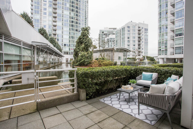 Spacious rooftop terrace with modern furniture, cityscape views, and a serene water feature. - THA - 1199 Marinaside Cres, Vancouver Downtown