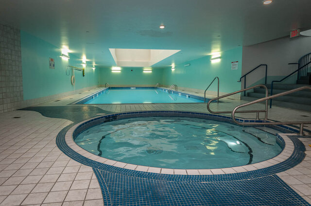 Spacious indoor pool area with tiled floors and a hot tub, perfect for relaxation. - THA - 1199 Marinaside Cres, Vancouver Downtown