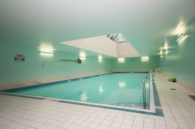 Spacious indoor pool area with skylight and tiled flooring, perfect for relaxation and exercise. - THA - 1199 Marinaside Cres, Vancouver Downtown